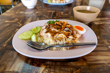 Steamed chicken fillet on a plate with a slice of cucumber to eat a meal with rice and sauce