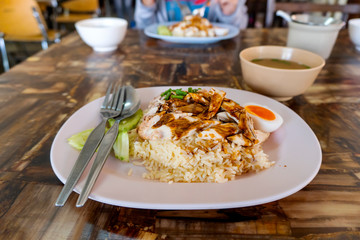 Steamed chicken fillet on a plate with a slice of cucumber to eat a meal with rice and sauce