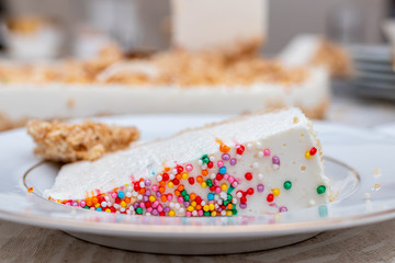 A piece of birthday cake on white table background.