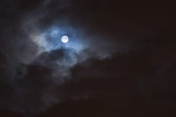 Fototapeta na wymiar full moon among the clouds in the night sky