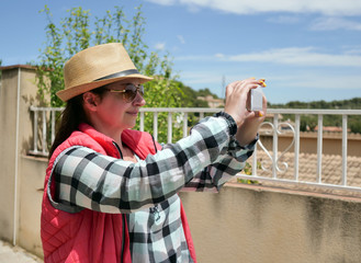 Attractive tourist girl takes a photo on her mobile phone