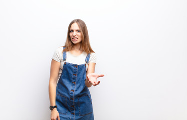 young pretty woman looking angry, annoyed and frustrated screaming wtf or what‚Äôs wrong with...