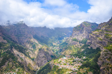 Amazing Curral das Freiras, known as Valley of the Nuns in Madeira, Portugal. Beautiful village surrounded by rocks and mountains. Portuguese landscape. Clouds in the valley. Tourist destination