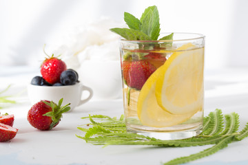 Infused water made from blueberry strawberry and lemon in sparkling mineral water look so freshness and healthy. Mixed fruit mojito on wood table with copy space. Summer refreshing drink concept. Ice 