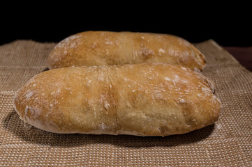 Closeup of two chiabatas on black background