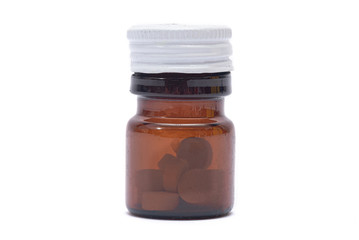 Brown jar with white cover with tablets within isolated on white background.
