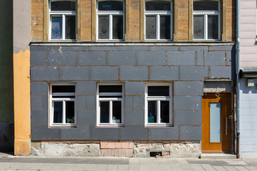 Fototapeta na wymiar Wärmedämmung und Sanierung eines Wohnhauses mit 3 Stockwerken in einer deutschen Kleinstadt, die oberen Stockwerke sind mit Sandstein gebaut