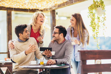 Group of friends in cafe, using digital devices