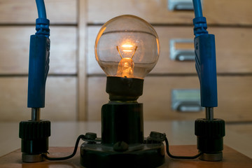 Glowing traditional Tungsten light bulb in physics class