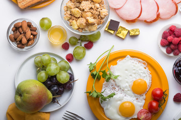 Homemade breakfast with sunny side up fried egg croissant toast coffee fruits vegetable and orange juice in top view with copy space. Delicious homemade american breakfast concept for background. Amer