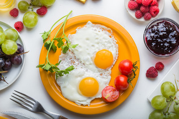 Homemade breakfast with sunny side up fried egg croissant toast coffee fruits vegetable and orange juice in top view with copy space. Delicious homemade american breakfast concept for background. Amer