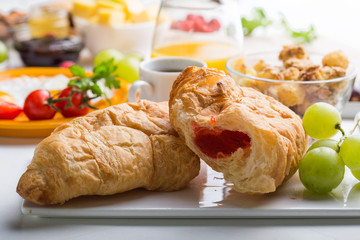 Homemade breakfast with sunny side up fried egg croissant toast coffee fruits vegetable and orange juice in top view with copy space. Delicious homemade american breakfast concept for background. Amer