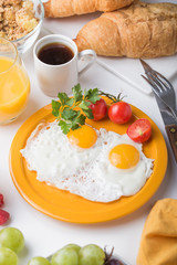 Homemade breakfast with sunny side up fried egg croissant toast coffee fruits vegetable and orange juice in top view with copy space. Delicious homemade american breakfast concept for background. Amer
