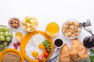 Homemade breakfast with sunny side up fried egg croissant toast coffee fruits vegetable and orange juice in top view with copy space. Delicious homemade american breakfast concept for background. Amer