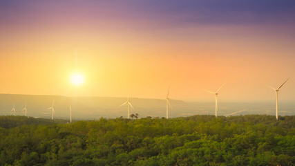 Fototapeta na wymiar wind turbine or windmill is alternative energy and green technology with beautiful sunset and colorful sky and tree on a the mountain and landscaping shot photo, with copy space.