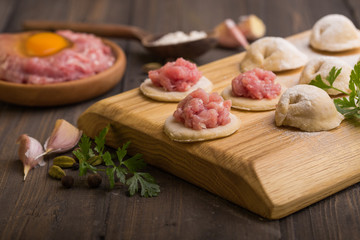 process of making home-made dumplings. Raw homemade dumplings on a wooden board. russian dumplings