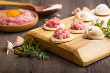 process of making home-made dumplings. Raw homemade dumplings on a wooden board. russian dumplings