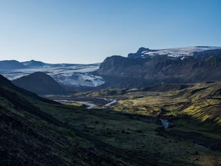 Fototapeta premium Icelandic landscape with eyjafjallajokull glacier tongue, Markarfljot river and green hills. Fjallabak Nature Reserve, Iceland. Summer blue sky