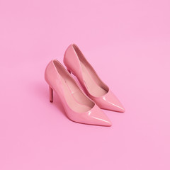 Pink patent leather shoes on a pink background. Pastel colours trends