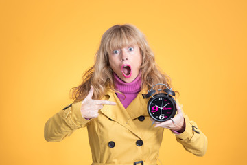 Fototapeta premium adult woman with alarm clock or alarm isolated on color background