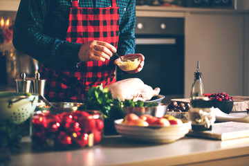 Mann bereitet leckeres und gesundes Essen in der häuslichen Küche zu Weihnachten zu (Weihnachtsente oder gans) - obrazy, fototapety, plakaty