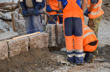 Workers establish a stone curb