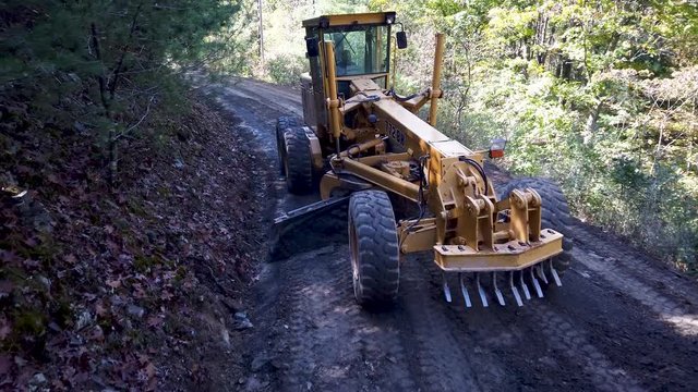 Closeup high shot of excavator scraping dirt making a new road in a forest area.