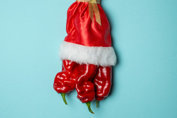 New Year pepper on a blue background, christmas table products, hot pepper in santa costume