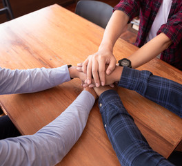 Close up of young business people putting and join their hands together. Business teamwork concept.