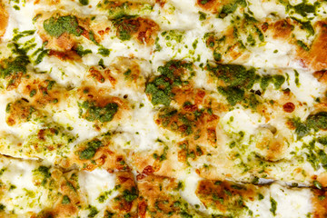 Obraz na płótnie Canvas Appetizing focaccia with pesto. Traditional italian food. Close-up. Background. Space for text.