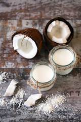 Jars of coconut milk, coconut flakes, coconut. Coconut milk extraction. Vegan milk. Selective focus. Macro.