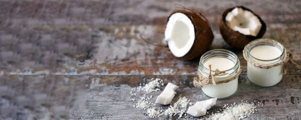 Jars of coconut milk, coconut flakes, coconut. Coconut milk extraction. Vegan milk. Selective focus. Macro.