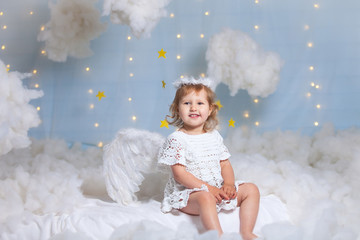 angel child is sitting the clouds looks down