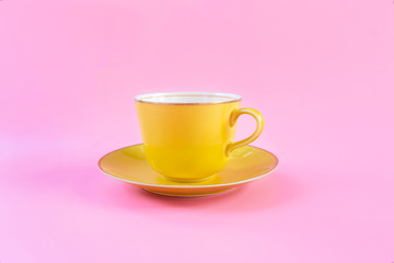 Empty yellow cup on pink pastel color background. Yellow mug empty blank for coffee or tea. concept relax