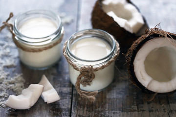 Jars of coconut milk, coconut flakes, coconut. Coconut milk extraction. Vegan milk. Selective focus. Macro.