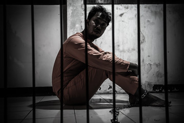 Fototapeta na wymiar Asian man desperate at the iron prison,prisoner concept,thailand people,Hope to be free,Serious prisoners imprisoned in the prison