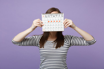 Woman hold cover face hiding female periods calendar for checking menstruation days isolated on...