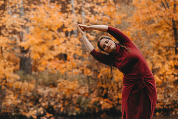 Curvy girl doing yoga in nature.