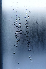 drops of water on a window pane against the sky