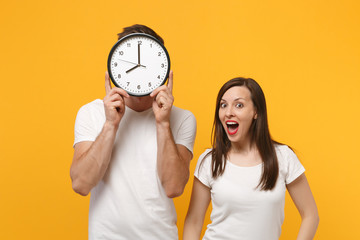 Funny young couple two friends guy girl in white empty blank design t-shirts posing isolated on...