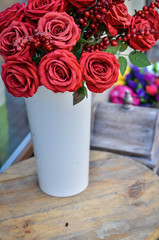 Close up of bouquet of red roses standing on a rustic table