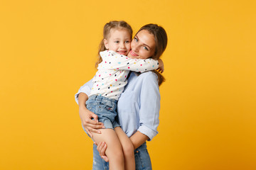 Woman in light clothes have fun with cute child baby girl 4-5 years old. Mommy little kid daughter isolated on yellow background studio portrait. Mother's Day love family parenthood childhood concept.