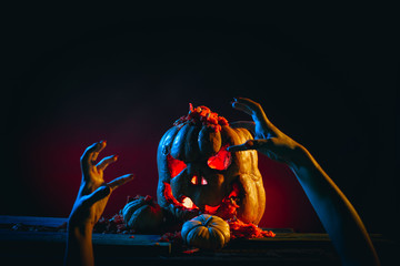 Scary Halloween pumpkins with hands in a spooky place at night. Poster concept.