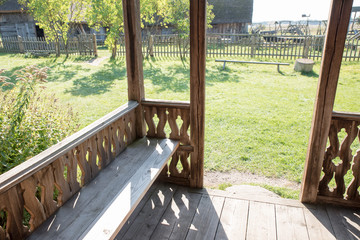 View from an old traditional wooden living house in village. Ancient village house. Sitting bench at home