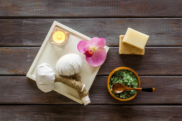 Preparing for massage in spa salon - with candles and orchids - dark wooden background top view pattern