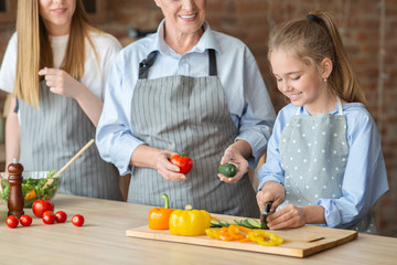 Adorable girl learning how to cut vegetables