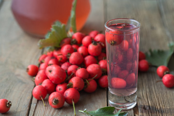 Hot tea from hawthorn berries in transparent glasses on a wooden table