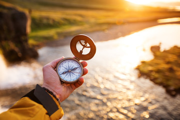 Beautiful landscape with old compass on traveler's hand. Traveling concept. - obrazy, fototapety, plakaty