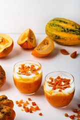Pumpkin raw dessert. Pumpkin smoothie with yogurt and dried apricots in glasses on a white background. Autumn healthy homemade diet food