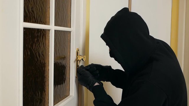 Burglar wearing balaclava mask at crime scene. Housing thief. Burglar in a house inhabited